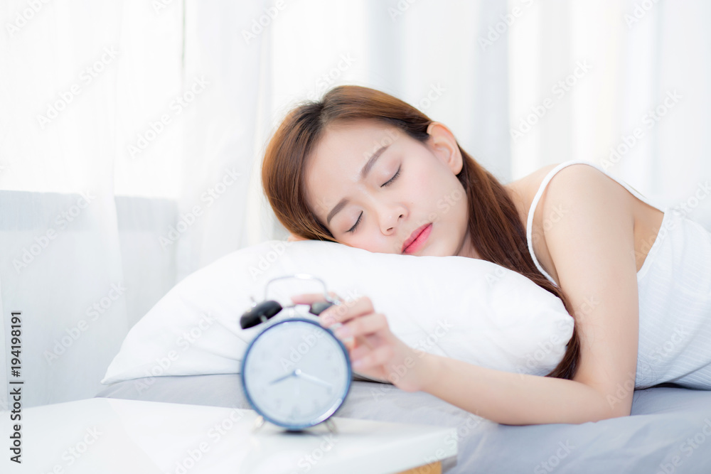 Beautiful asian young woman turn off alarm clock in morning, wake up for sleep with alarm clock, relax and lifestyle concept. Beautiful asian young woman turn off alarm clock in morning, wake up for sleep with alarm clock, relax and lifestyle concept.
