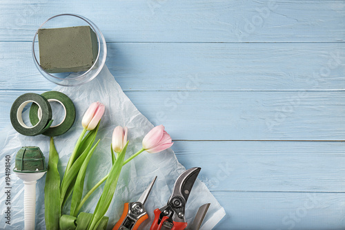 Florist equipment with flowers on wooden background