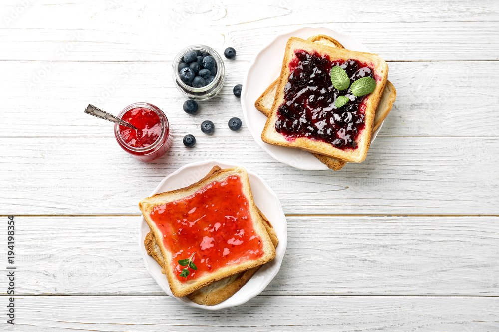 Delicious toasts with sweet jams on wooden background - obrazy, fototapety, plakaty 