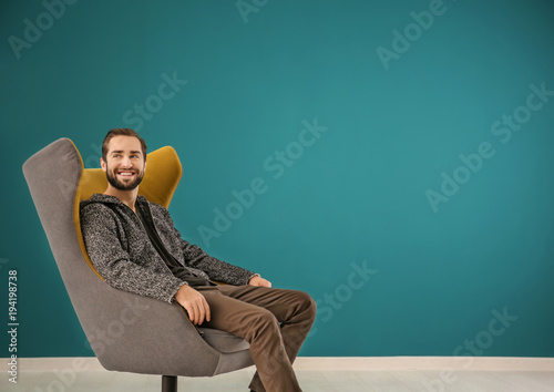 Handsome man sitting in com...
