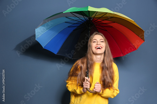 Young woman with rainbow um...