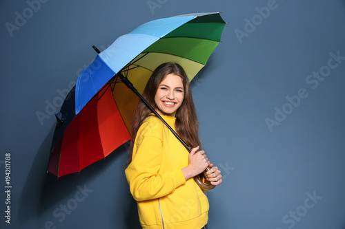 Young woman with rainbow um...