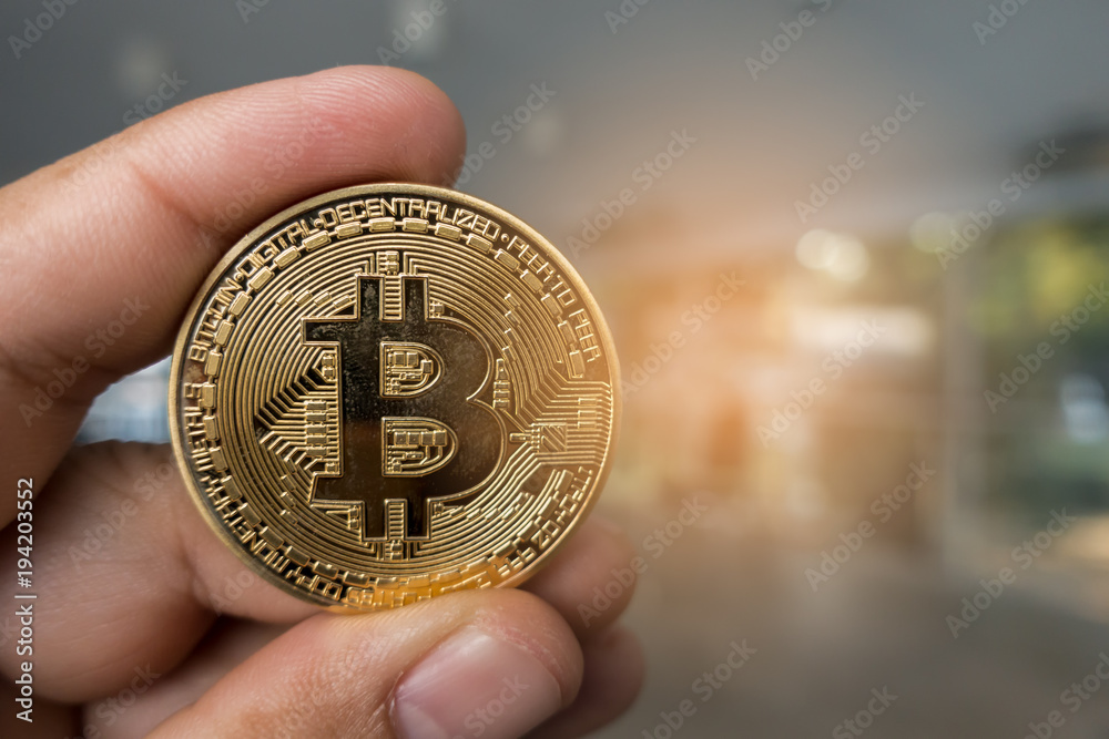 Closeup Golden bitcoin coin in a business office. Closeup Golden bitcoin coin in a business office.