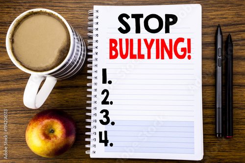 Handwritten text showing Stop Bullying. Business concept for Prevention Problem Bully written on notepad note paper on the wood structure background background. photo