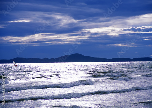 Sunlit sea waves under stormy sky