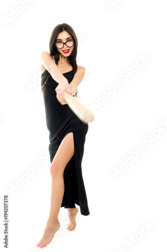 Young beautiful woman in a black dress with a baseball bat on a white background