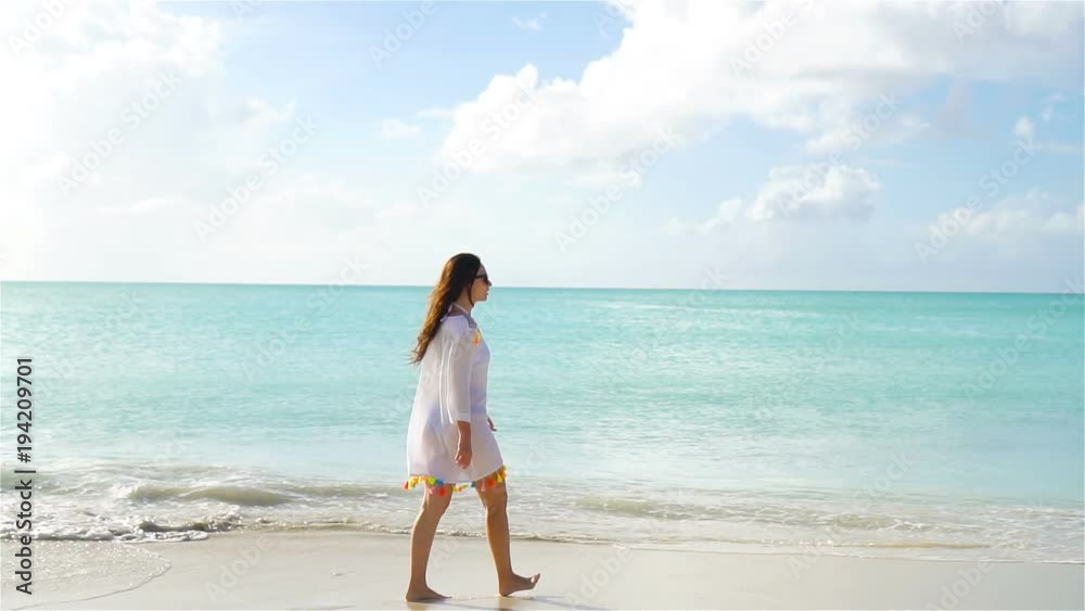 Young beautiful woman having fun on th beach. Back view of girl on the caribbean seashore. SLOW MOTION Young beautiful woman having fun on th beach. Back view of girl on the caribbean seashore. SLOW MOTION