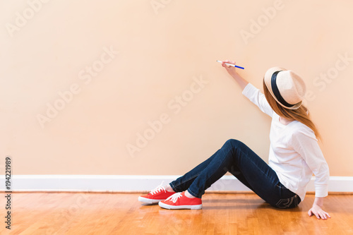 Young woman drawing something on a big open wall