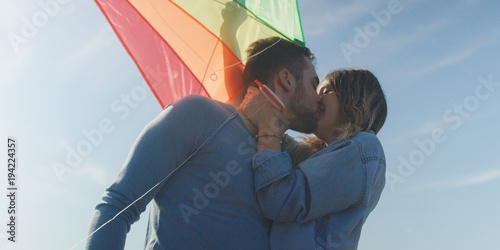 Happy couple having fun with kite on beach