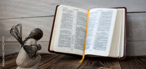 angel and bible on a wooden background photo