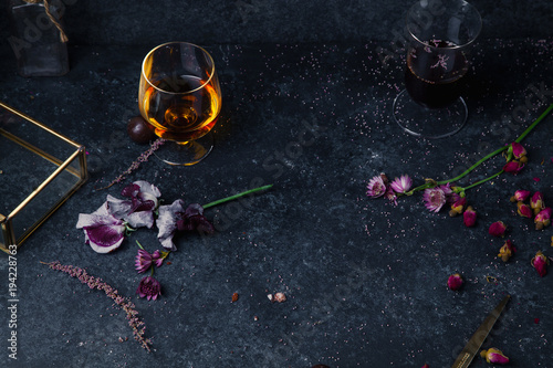 Dried and fresh flowers on dark background with chocolate and whiskey. Chocolate chic concept