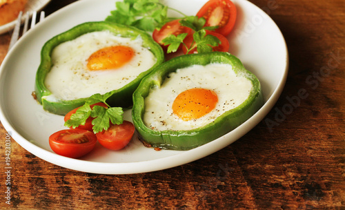 Fried egg in the ring of the bell peppers with herbs