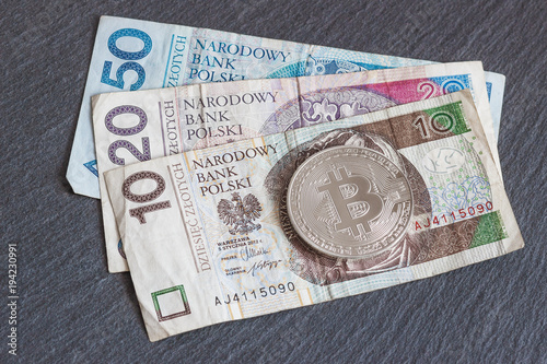 Polish zloty and bitcoin on the black slate stone background