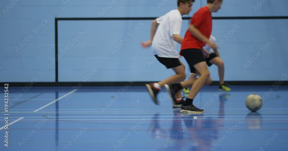 4k, Children's soccer team playing indoors at a school gym. Shot in slow motion