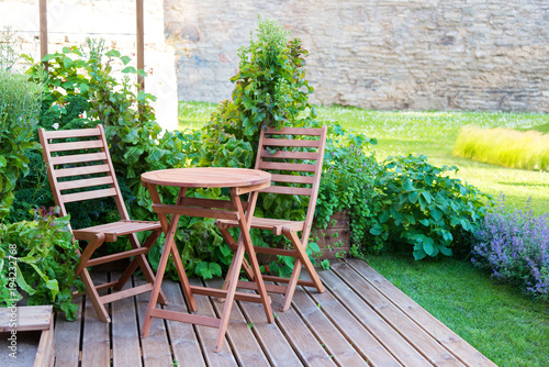 empty wood table and chairs on the terrace at summer day