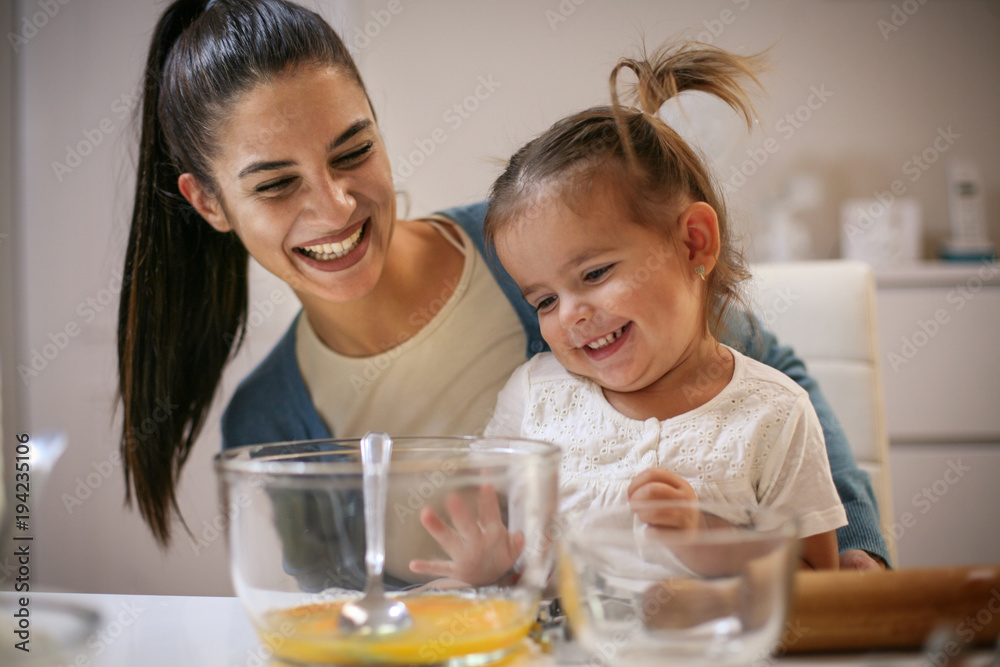Mother and daughter in kitchen. Mother and daughter baking cookies together. Mother and daughter in kitchen. Mother and daughter baking cookies together.