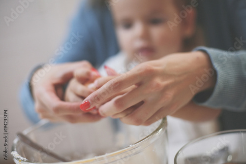 Mother and daughter in kitchen. Mother and daughter baking cookies together. Focus on hands. Close up.
