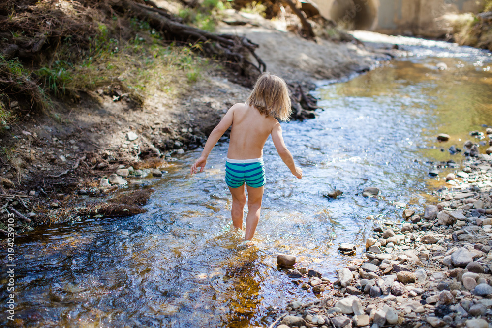 Boy wades in a creek Boy wades in a creek