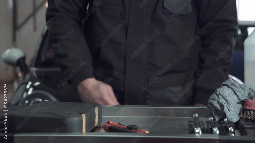 Car auto service - worker grinding metal construction with a circular saw Car auto service - worker grinding metal construction with a circular saw