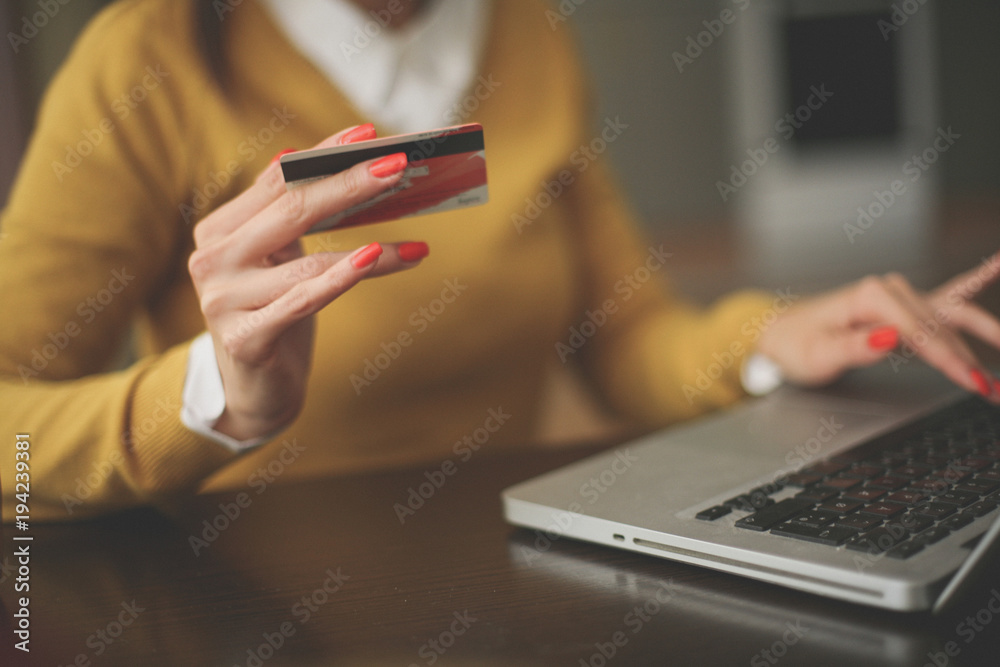 Young woman using laptop and credit card. Close up.