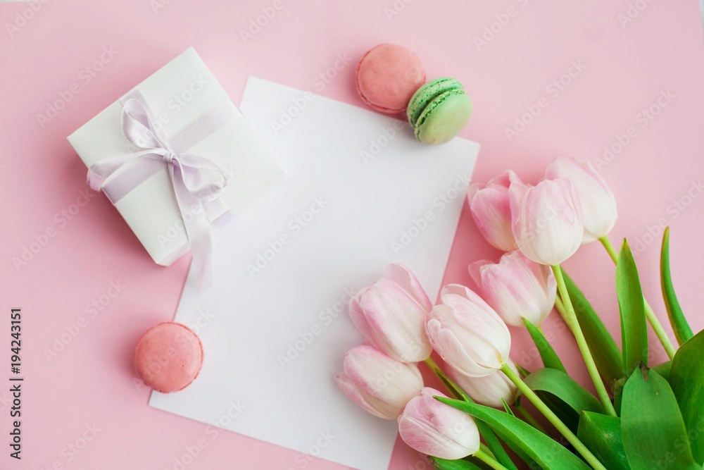 A bouquet of tulips, a gift card on a pink background. Gift. A box with a gift. International Women's Day. Holidays. Spring. Macaroons.