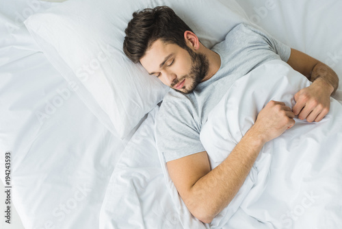 top view of bearded man sleeping on bed photo