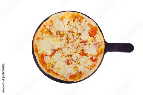 Pizza whole round on a black tray, blackboard, cut into pieces, on a white isolated background. Fast food in a pizzeria, a floury cheese product. View from above