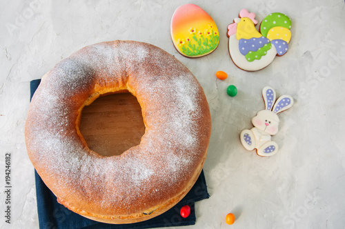 Reindling - Austrian or German festive baking for Easter. Ring cake served on a wooden plate on a white stone background.
