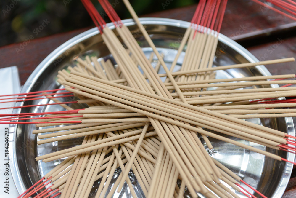 Group of incense sticks be superimposed on tray prepared for paying respect in the Buddhist temple Group of incense sticks be superimposed on tray prepared for paying respect in the Buddhist temple