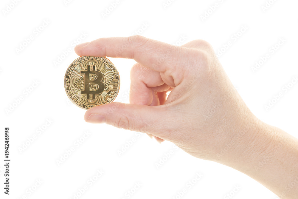Female hand holding a bitcoin between the fingers on a white background Female hand holding a bitcoin between the fingers on a white background