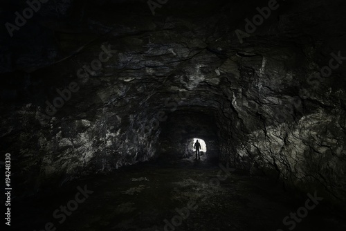man in a dark cave watch out of the exit - depression concept