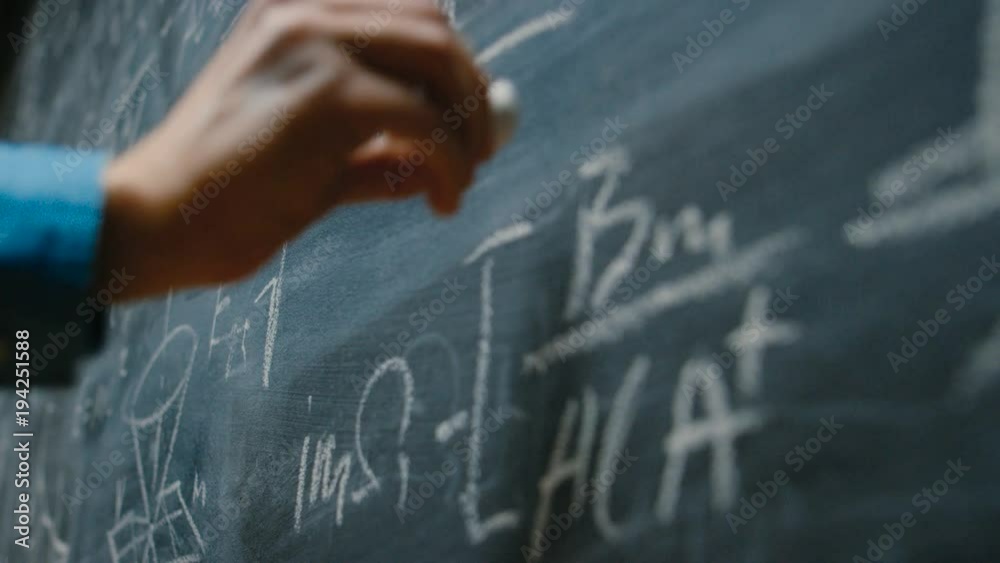 Hand Holding Chalk and Writing Complex and Sophisticated Mathematical Formula/ Equation on the Blackboard.