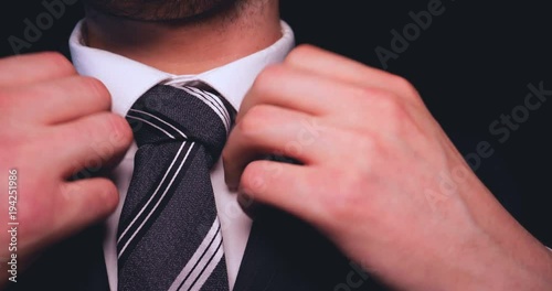 Businessman in suit, black background.