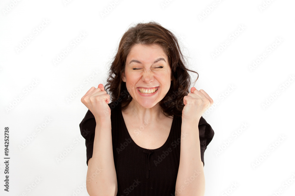 Portrait of a happy young woman clenches his fists being champion and successful person. Happiness concept Portrait of a happy young woman clenches his fists being champion and successful person. Happiness concept