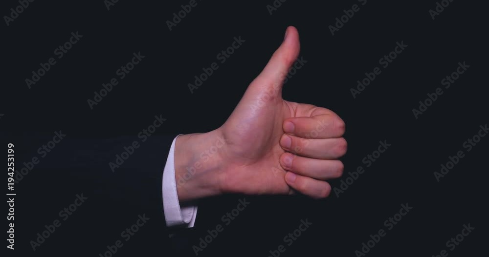 Businessman in suit, thumb up (like), black background. Businessman in suit, thumb up (like), black background.