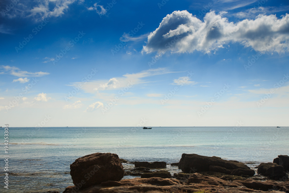 Small Rocks in Water by Coast against Azure Sea Blue Sky Small Rocks in Water by Coast against Azure Sea Blue Sky