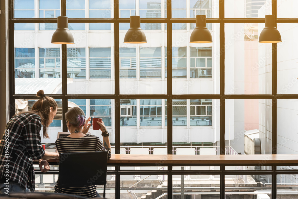 Two freelance working in coffee shop, Nomad worker conceptual, couple having fun work together in cafe Two freelance working in coffee shop, Nomad worker conceptual, couple having fun work together in cafe