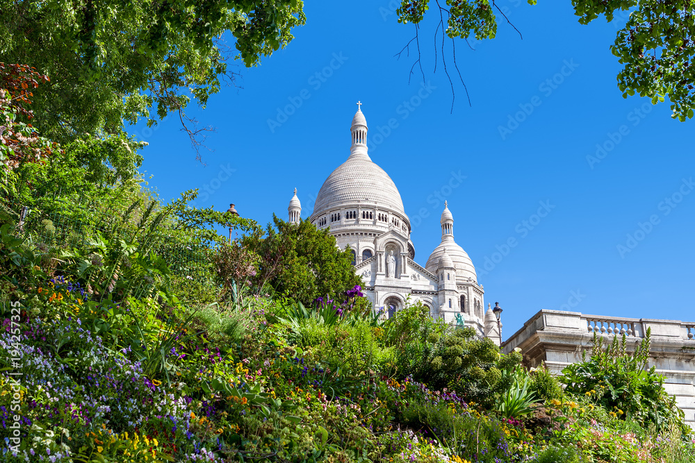 Sacre-Coeur Basilica and green flowerbed in Paris.