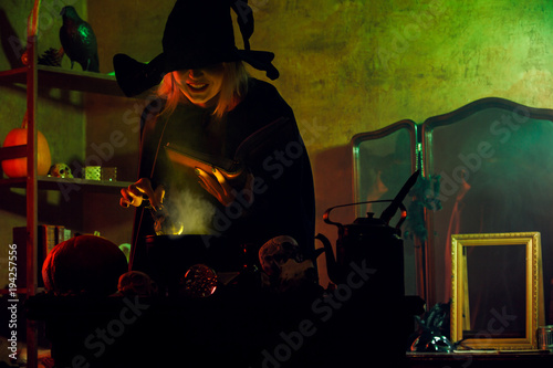 Image of witch in black hat reading spell over pot of green steam