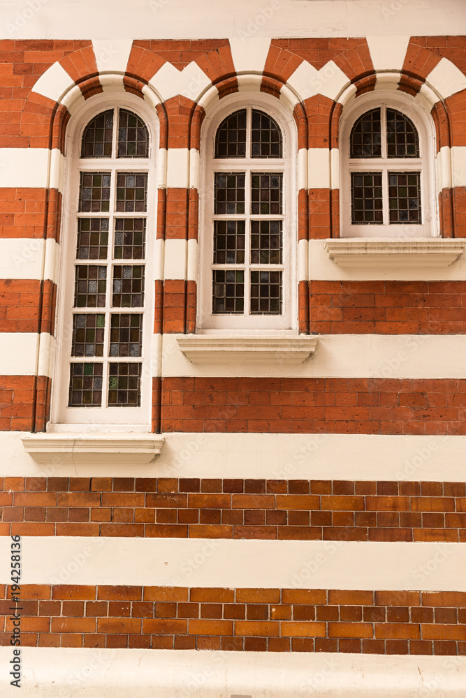 Ventanas en arco en fachada de ladrillo rojo y blanco. Stock Photo