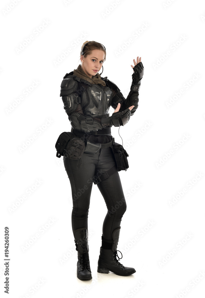 full length portrait of female soldier wearing black tactical armour with arms raised, isolated on white studio background. full length portrait of female soldier wearing black tactical armour with arms raised, isolated on white studio background.