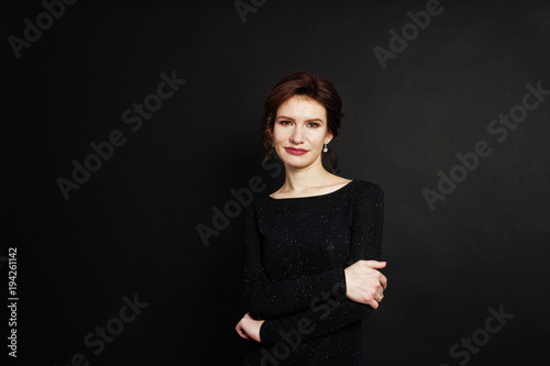 Elegance woman in black evening dress posed on studio isolated on black.
