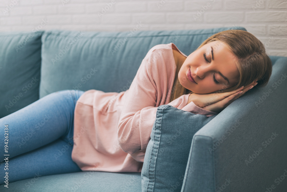 Beautiful woman enjoys napping on the sofa at her home. Beautiful woman enjoys napping on the sofa at her home.