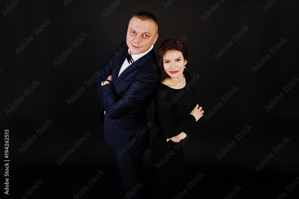 Elegance woman in black evening dress with man in suit posed on studio isolated on black. Duet couple of two. Elegance woman in black evening dress with man in suit posed on studio isolated on black. Duet couple of two.