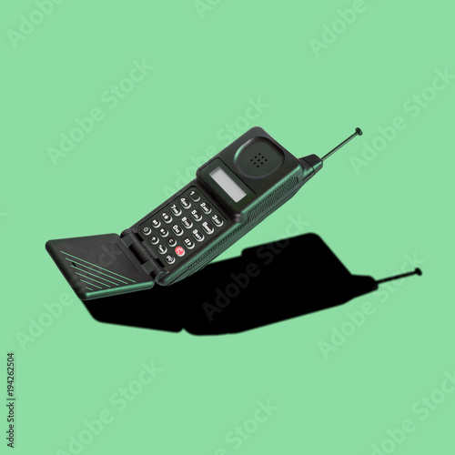 Old classic analog mobile phone nostalgia in punchy color, with aerial and microphone flip, for creative design cover, CD, poster, book, printing, gift card, flyer, magazine web & print
