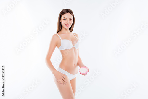 Pampering grooming irritation ideal perfect sensitive skin natural concept. Portrait of beautiful skinny slim sporty stunning woman gently touching leg holding pink jar isolated on white background © deagreez