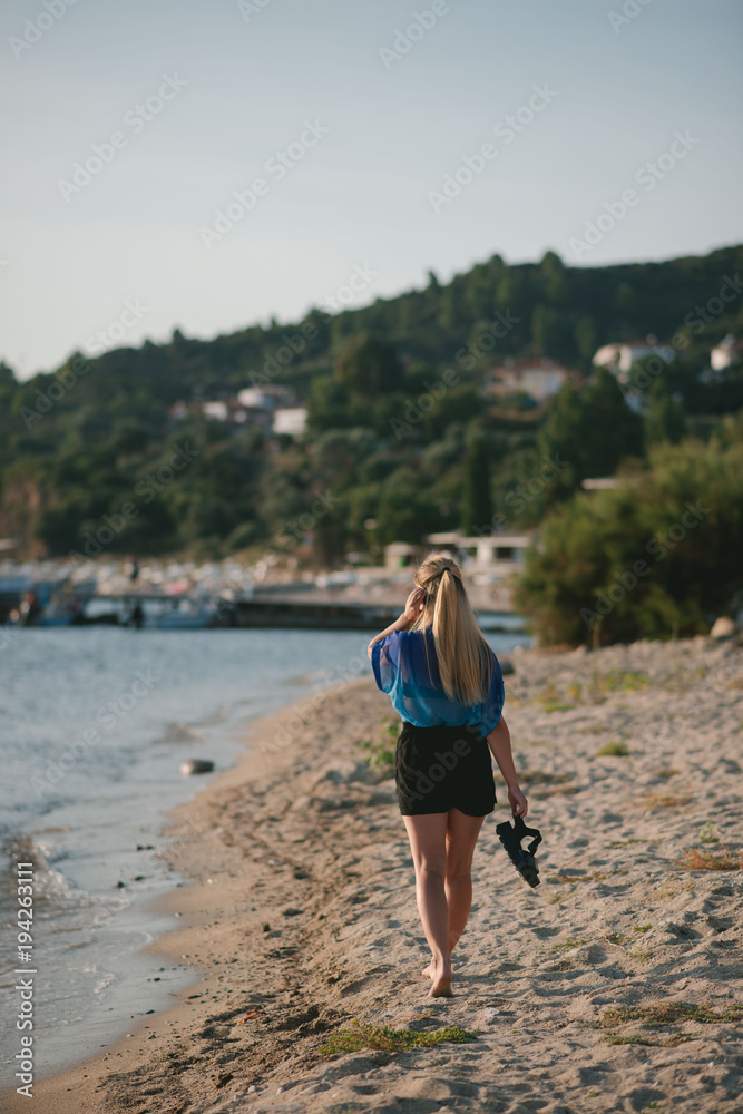 The girl walks along the beach