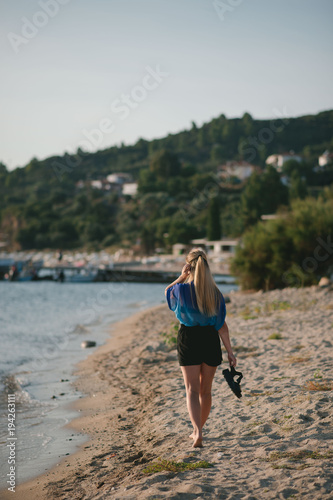The girl walks along the beach