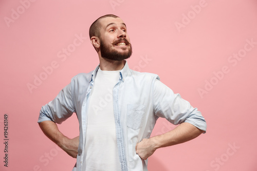 The happy business man standing and smiling against pastel background.