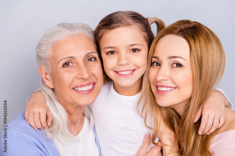 Close up portrait of cute nice friendly lovely adorable beautiful with toothy beaming smile embracing family isolated on gray background Close up portrait of cute nice friendly lovely adorable beautiful with toothy beaming smile embracing family isolated on gray background